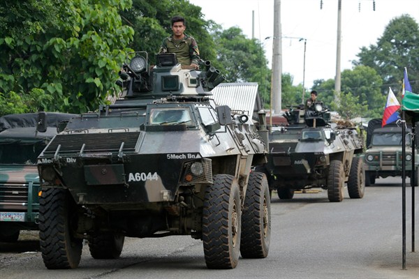 A military convoy passes a checkpoint on the outskirts of Marawi, Philippines, June 9, 2017 (AP photo by Aaron Favila).