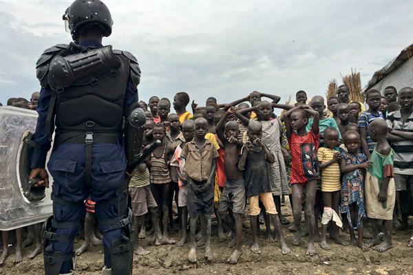 A crowd of displaced people look on as members of the U.N. multinational police contingent provide security during a visit of UNHCR High Commissioner Filippo Grandi, Bentiu, South Sudan, June 18, 2017 (AP photo by Sam Mednick).