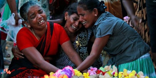 Sri Lankan ethnic Tamil women cry at the graves of relatives who died in fighting between the army and Tamil Tiger rebels, Mullivaikkal, Sri Lanka, May 18, 2015 (AP photo by Eranga Jayawardena).