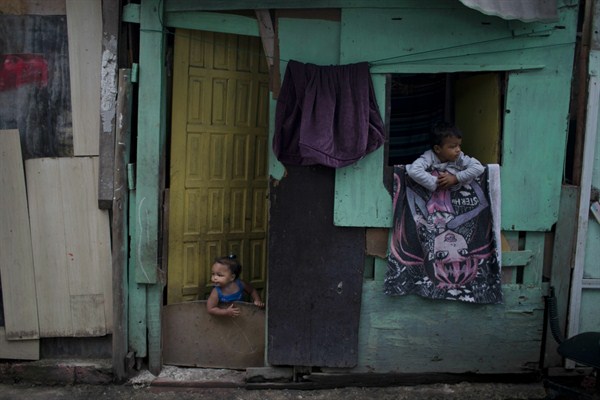 Kids peer out from their shack in one of the poorest areas of the City of God favela, Rio de Janeiro, June 10, 2017 (AP photo by Leo Correa).