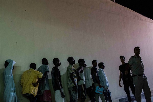 Security forces line up Sudanese migrants detained at a police station after they were rescued from a boat that capsized in the Mediterranean Sea, Rosetta, Egypt, Sept. 21, 2016 (AP photo by Eman Helal).