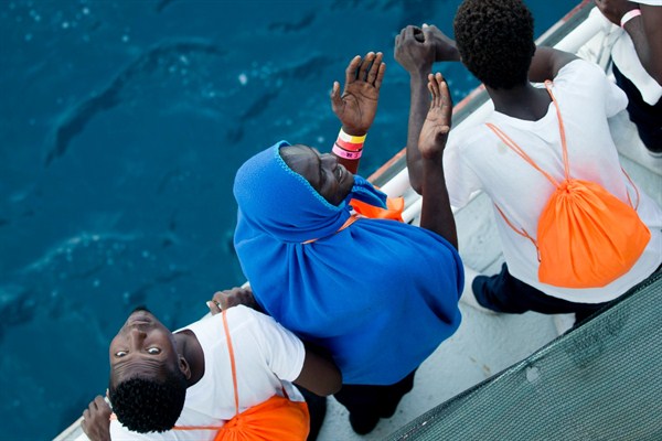 African migrants who were rescued from the Mediterranean Sea north of the Libyan coast look up from the deck as they approach Sicily, Sept. 1, 2017 (AP photo by Darko Bandic).