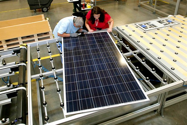 A quality control manager at a Suntech Power Holdings Co., a Chinese-owned solar panel manufacturer, examines a solar panel with a co-worker at a company facility in Goodyear, Ariz., Sept. 4, 2012 (AP photo by Ross D. Franklin).