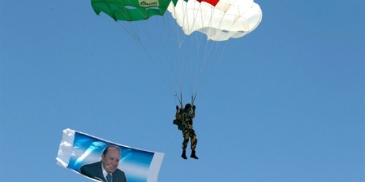An Algerian paratrooper jumps by a flag showing Algerian President Abdelaziz Bouteflika during a military show, Algiers, July 5, 2017 (AP photo by Anis Belghoul).