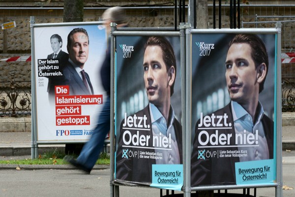 A person passes posters of the right-wing Freedom party, FPOE, and the conservative Austrian People's Party, OEVP, Vienna, Austria, Oct.11, 2017 (AP photo by Ronald Zak).
