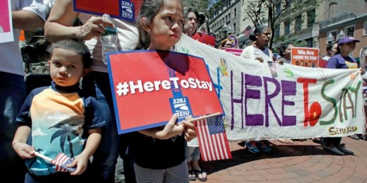 Nicole Castillo, 7, of East Boston, holds a sign while standing with her brother Diego, 4, and mother Elsa, who is originally from El Salvador, during a “Here to Stay” rally, Boston, July 6, 2017 (AP photo by Charles Krupa).