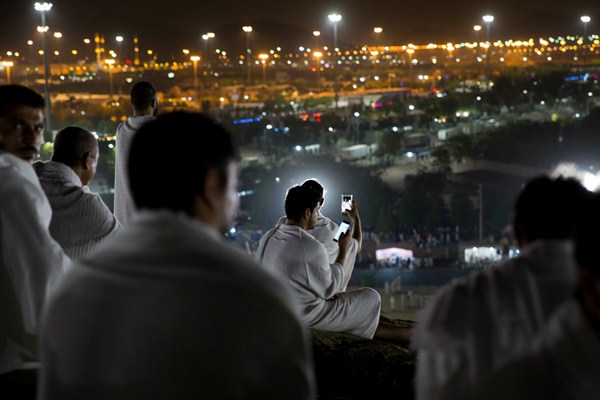 Muslim pilgrims use their mobile phones upon arrival for the annual hajj pilgrimage, outside of Mecca, Saudi Arabia, Aug. 30, 2017 (AP photo by Khalil Hamra).