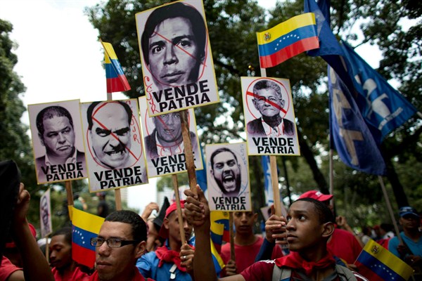 Supporters of the Venezuelan government hold pictures of opposition lawmakers during a march, Caracas, Venezuela, Sept. 11, 2017 (AP photo by Ariana Cubillos).