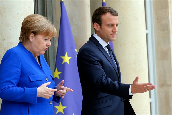 French President Emmanuel Macron greets German Chancellor Angela Merkel prior to a joint Franco-German cabinet meeting at the Elysee Palace in Paris, July 12, 2017 (AP photo by Michel Euler).