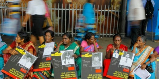 Sri Lankan ethnic Tamil women sit holding placards with portraits of their missing relatives as they protest outside a railway station in Colombo, Sri Lanka, April 6, 2015 (AP photo by Eranga Jayawardena).