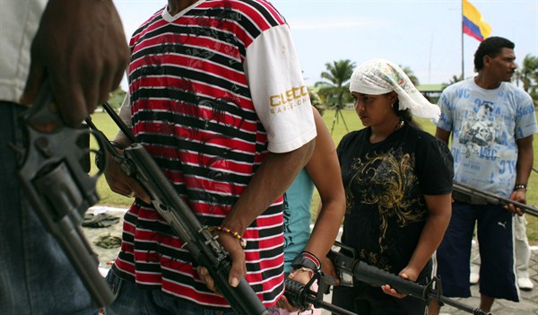 Demobilized ELN rebels wait in line to surrender their weapons at a military base, Tumaco, Colombia, April 3, 2009 (AP photo by William Fernando Martinez).