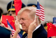 Children wave U.S. and Chinese flags as President Donald Trump arrives at the airport in Beijing, China, Nov. 8, 2017 (AP photo by Andrew Harnik).