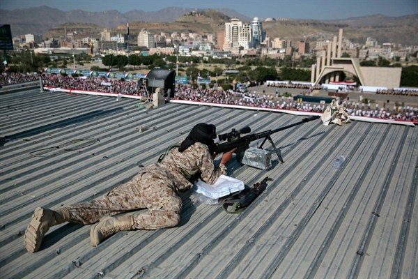 A Houthi sniper keeps watch over a rally to mark the third anniversary of the Houthis’ takeover of the Yemeni capital, Sanaa, Sept. 21, 2017 (AP photo by Hani Mohammed).