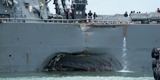 Damage to the portside is visible as the USS John S. McCain steers toward a naval base in Singapore following a collision, Aug. 21, 2017 (U.S. Navy photo via AP).