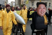 An anti-war protester wears a mask showing North Korean leader Kim Jong Un during a demonstration against nuclear weapons, Berlin, Germany, Nov. 18, 2017 (AP photo by Michael Sohn).