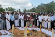 Sri Lankan Tamil activists observe a moment of silence near a makeshift monument where thousands were killed in fighting between the army and Tamil Tiger rebels, Mullivaikkal, Sri Lanka, May 18, 2015 (AP photo by Eranga Jayawardena).