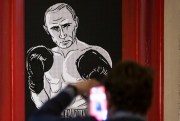 A man takes a picture of an artwork depicting Russian President Vladimir Putin as boxing legend Muhammad Ali during the “Putin Universe” exhibition, Moscow, Russia,  Oct. 7, 2015 (AP photo by Pavel Golovkin).