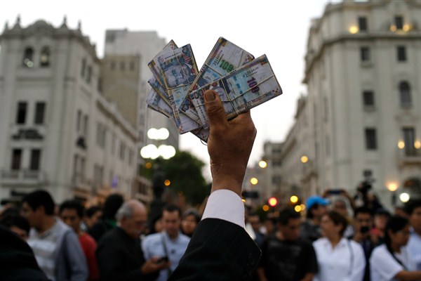 A protester holds up fake money during an anti-corruption march in Lima, Peru, Dec. 20, 2017 (AP photo by Martin Mejia).