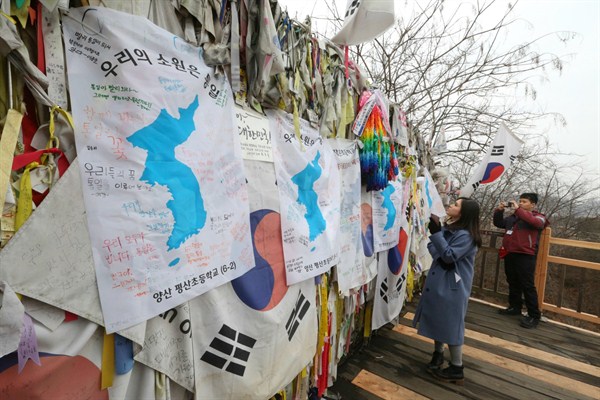 Visitors hang ribbons and unification flags on a fence near the border with North Korea, Paju, South Korea, Jan. 18, 2018 (AP photo by Ahn Young-joon).