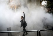 A student participates in a protest inside Tehran University as a smoke grenade is thrown by anti-riot police, Tehran, Iran, Dec. 30, 2017 (AP photo).
