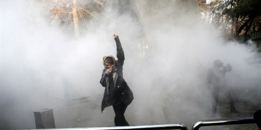 A student participates in a protest inside Tehran University as a smoke grenade is thrown by anti-riot police, Tehran, Iran, Dec. 30, 2017 (AP photo).