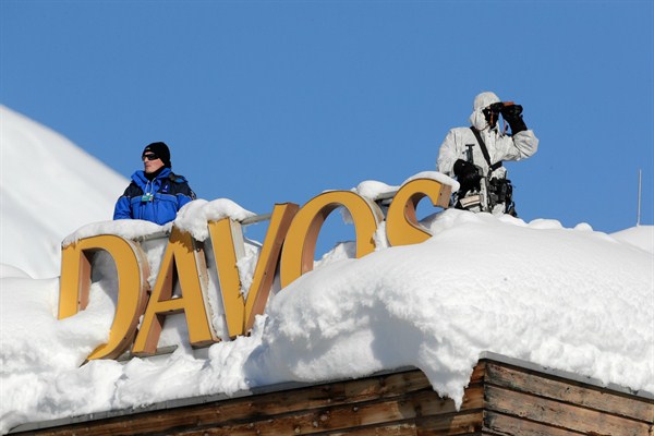 Armed Swiss police officers stand guard on the roof of a hotel near the facility where the annual meeting of the World Economic Forum takes place in Davos, Switzerland, Jan. 23, 2018 (AP photo by Markus Schreiber).