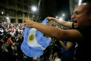 A demonstrator waves an Argentine flag as a crowd marches to the Congress to protest the recent pension reform, Buenos Aires, Argentina, Dec. 19, 2017 (AP photo by Victor R. Caivano).