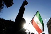A demonstrator shouts slogans near the flag of the former Imperial State of Iran as he gathers with opposition supporters outside the Iranian embassy in Rome, Italy, Jan. 2, 2018 (AP photo by Gregorio Borgia).