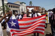 Liberians march with the national flag in the streets of Monrovia, Liberia, May 11, 2015 (AP photo by Abbas Dulleh).