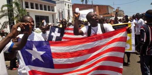 Liberians march with the national flag in the streets of Monrovia, Liberia, May 11, 2015 (AP photo by Abbas Dulleh).