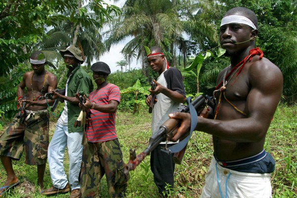Ijaw millitants carry Russian-made AK-47 rifles in Okorota, Nigeria, June. 25, 2004 (AP photo by George Osodi).