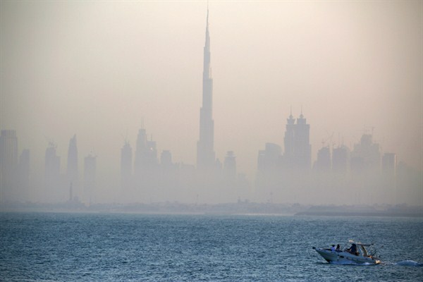 A boat passes by the skyline of downtown Dubai featuring the Burj Khalifa, the world's tallest building, UAE, Dec. 18, 2016 (AP photo by Jon Gambrell).