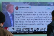 People watch a TV news program showing the Twitter post in which U.S. President Donald Trump boasted about the size of his  “nuclear button,” Seoul, South Korea, Jan. 3, 2018 (AP photo by Ahn Young-joon).