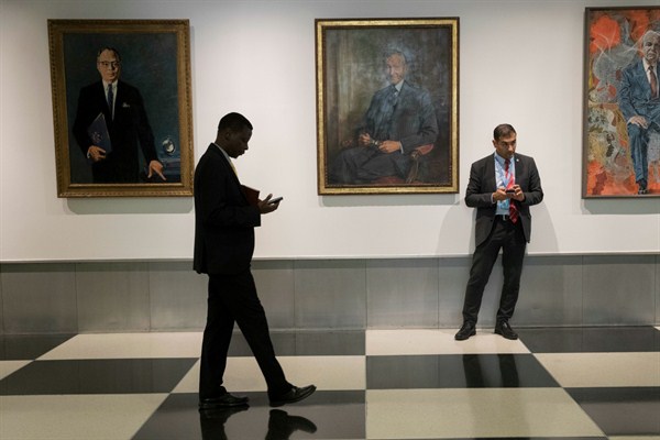 People walk past portraits of former United Nations Secretaries-General during the General Assembly at U.N. headquarters, New York, Sept. 22, 2017 (AP photo by Mary Altaffer).