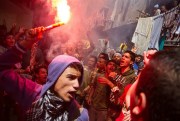 An Egyptian youth carries a lit flare as supporters of the Muslim Brotherhood protest in the El-Mataria neighborhood of Cairo, Egypt, April 24, 2015 (AP photo by Belal Darder).