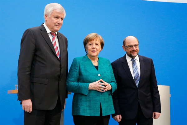 German Chancellor Angela Merkel flanked by the SPD’s Martin Schulz, right, and the CSU’s Horst Seehofer, after Merkel’s bloc and the SPD reached a deal to form a new coalition government, Berlin, Feb. 7, 2018 (AP photo by Ferdinand Ostrop).
