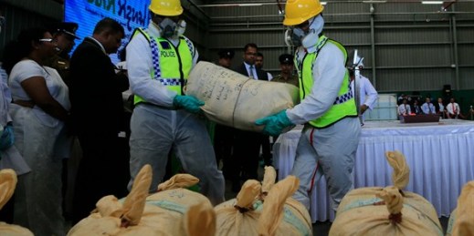 Sri Lankan police officers in protective costumes prepare to destroy a haul of seized cocaine at an industrial facility, Katunayaka, Sri Lanka, Jan. 15, 2018 (AP photo by Eranga Jayawardena).