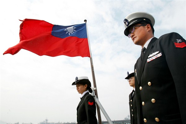 Taiwanese military officers stand beneath Taiwan's flag onboard a navy frigate during military exercises off Kaohsiung, Taiwan, Jan. 31, 2018 (AP photo by Chiang Ying-ying).