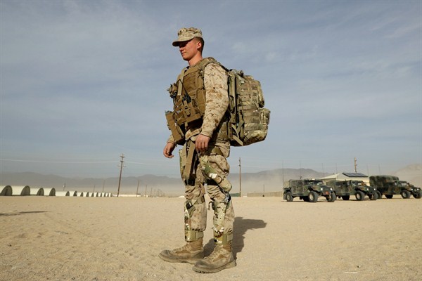 A U.S. Marine wears knee braces and a backpack that harvest energy from his movements during an exhibition of green energy technology, Twentynine Palms, California, Dec. 7, 2016 (AP photo by Gregory Bull).