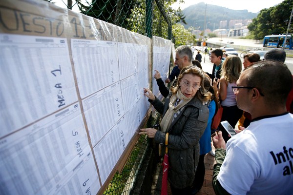 People check a voter list to confirm where they should cast their ballots during legislative elections, Bogota, Colombia, March 11, 2018 (AP photo by Fernando Vergara).