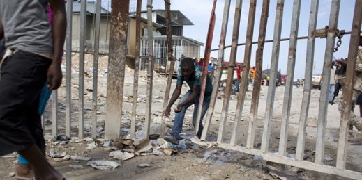A Haitian worker crosses the border fence separating the Dominican Republic town of Jimani from the Haitian town of Malpasse, August 26, 2015 (AP photo by Dieu Nalio Chery).