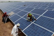 Indian workers install solar panels at the Gujarat Solar Park at Charanka, Patan district, India, April 14, 2012 (AP photo by Ajit Solanki).