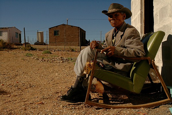 Jan Christians sits outside his home in the Richtersveld area, where locals live as they await the outcome of a lands claim action, North Western Cape Province, South Africa, March 2005 (AP photo by Mujahid Safodien).