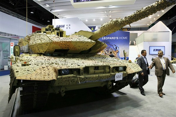 Two men walk past a German-made Krauss-Maffei Wegmann Leopard tank with a “sold” sign on it at the International Defense Exhibition and Conference in Abu Dhabi, United Arab Emirates, Feb. 22, 2017 (AP photo by Jon Gambrell).