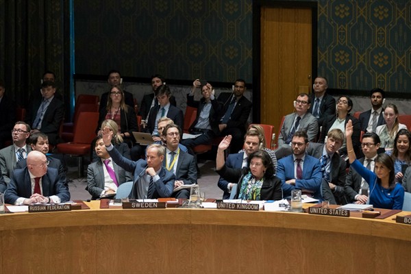 Russia’s ambassador to the U.N., Vassily Nebenzia, left, watches as the ambassadors of Sweden, the United Kingdom and the United States vote on a resolution at a Security Council meeting on Syria, April 14, 2018 (AP photo by Mary Altaffer).