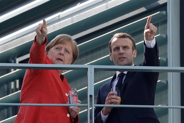 German Chancellor Angela Merkel and French President Emmanuel Macron take a break on the balcony of Merkel’s office after a meeting, Berlin, Germany, April 19, 2018 (AP photo by Michael Sohn).