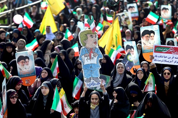 An Iranian woman holds up a caricature of U.S. President Donald Trump tearing a document during a rally marking the 39th anniversary of the 1979 Islamic Revolution, Tehran, Iran, Feb. 11, 2018 (AP photo by Ebrahim Noroozi).