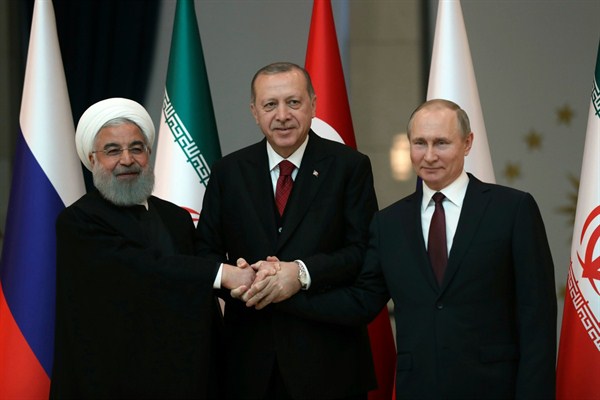 Iranian President Hassan Rouhani, Russian President Vladimir Putin and Turkish President Recep Tayyip Erdogan lock hands during a group photo, Ankara, Turkey, April 4, 2018 (Pool photo  by Tolga Bozoglu via AP).