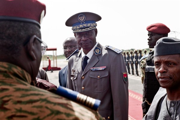 Gen. Gilbert Diendere greets people at the airport during the arrival of Nigerien President Mahamadou Issoufou for talks about the 2015 coup, Ouagadougou, Burkina Faso, Sept. 23, 2015 (AP photo).