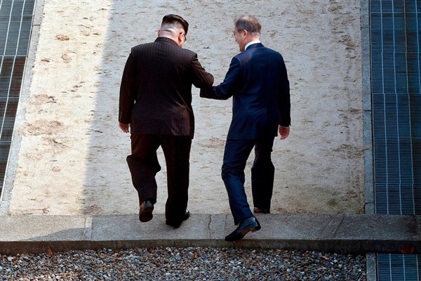 North Korean leader Kim Jong Un and South Korean President Moon Jae-in cross the military demarcation line in the border village of Panmunjom in the Demilitarized Zone, April 27, 2018 (Korea summit press pool photo via AP).